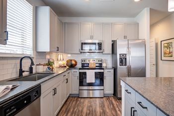 a kitchen with white cabinets and stainless steel appliances